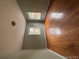 Spare room featuring baseboard heating, light wood-type flooring, and healthy amount of natural light Spare room featuring baseboard heating, light wood-type flooring, and healthy amount of natural light