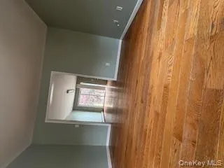 Empty room featuring light wood-style flooring and lofted ceiling Empty room featuring light wood-style flooring and lofted ceiling