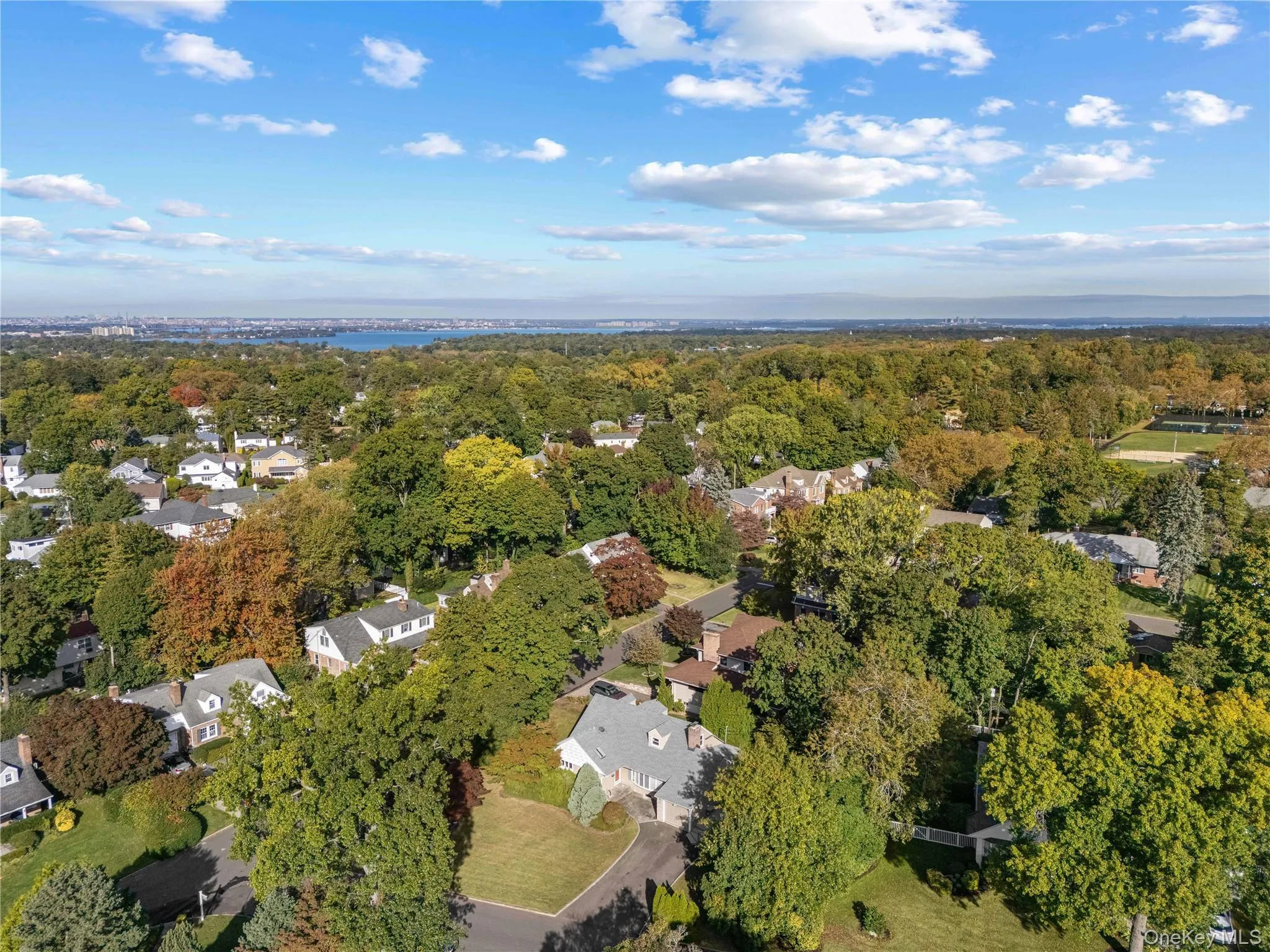 Aerial view of property and surrounding area with a large body of water and nearby suburban area Aerial view of property and surrounding area with a large body of water and nearby suburban area