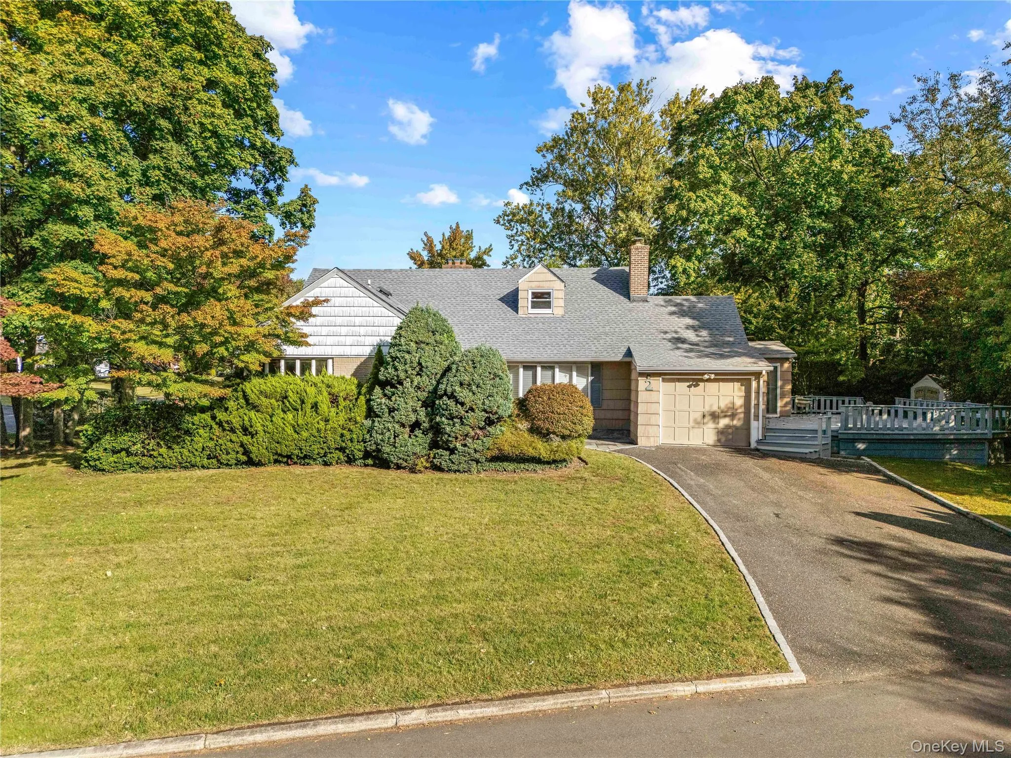 View of front of property featuring asphalt driveway, a chimney, a front yard, and an attached garage View of front of property featuring asphalt driveway, a chimney, a front yard, and an attached garage