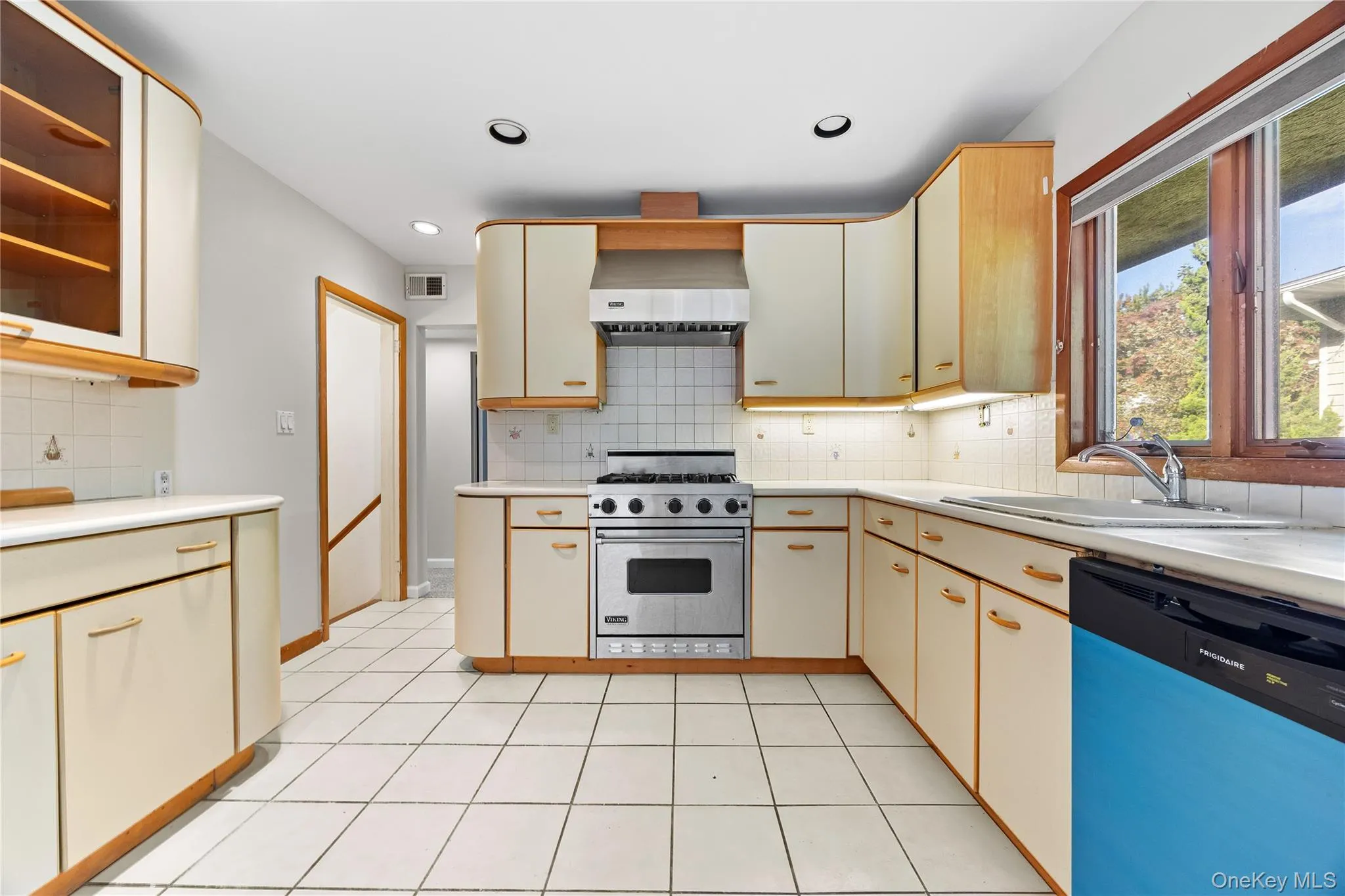 Kitchen with dishwashing machine, luxury range, decorative backsplash, light countertops, and recessed lighting Kitchen with dishwashing machine, luxury range, decorative backsplash, light countertops, and recessed lighting