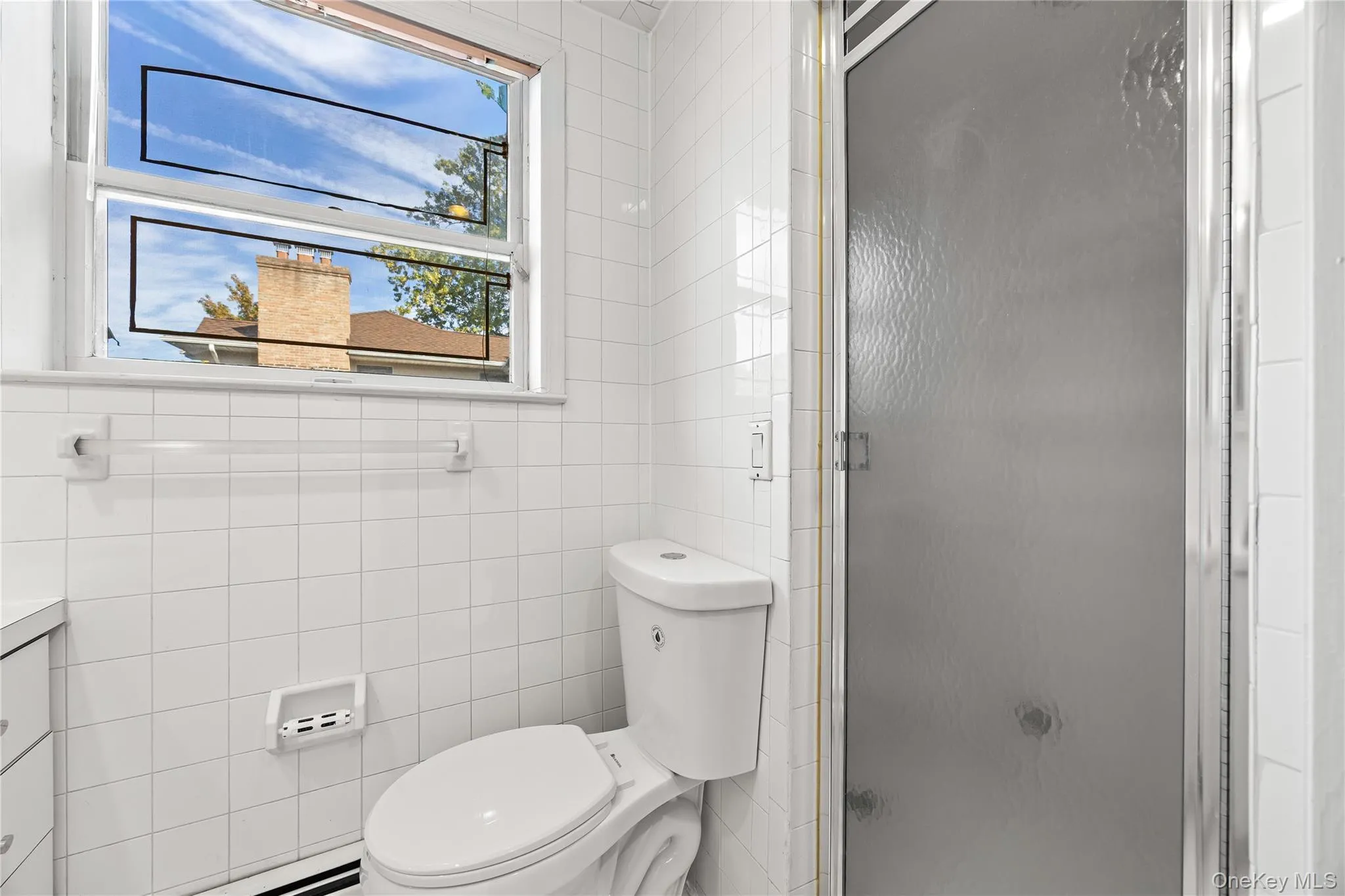 Bathroom with vanity, a stall shower, and tile walls Bathroom with vanity, a stall shower, and tile walls
