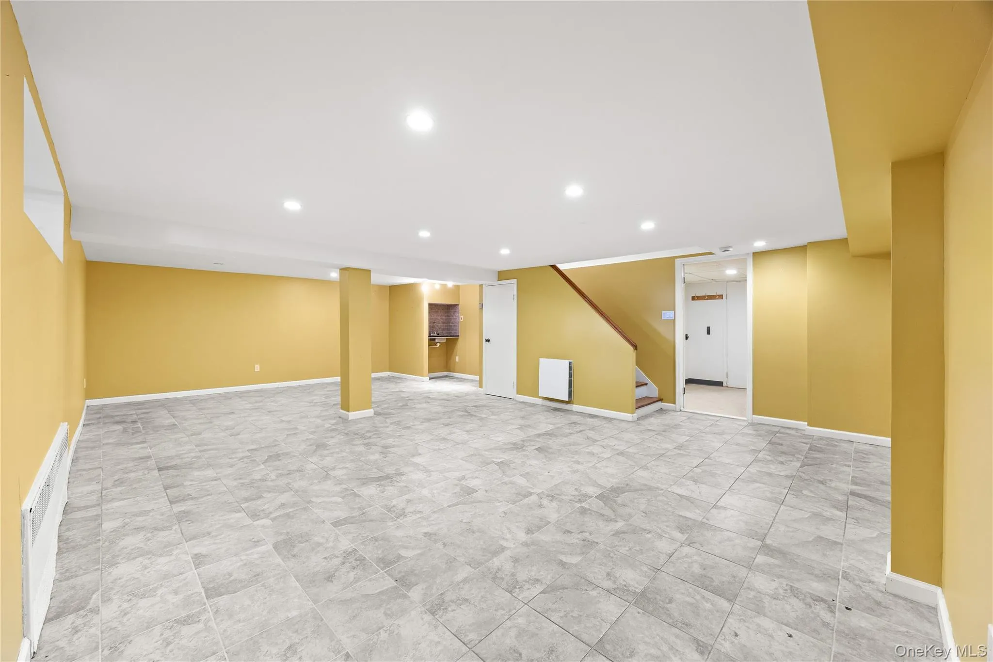 Finished below grade area with stairway and recessed lighting Finished below grade area with stairway and recessed lighting