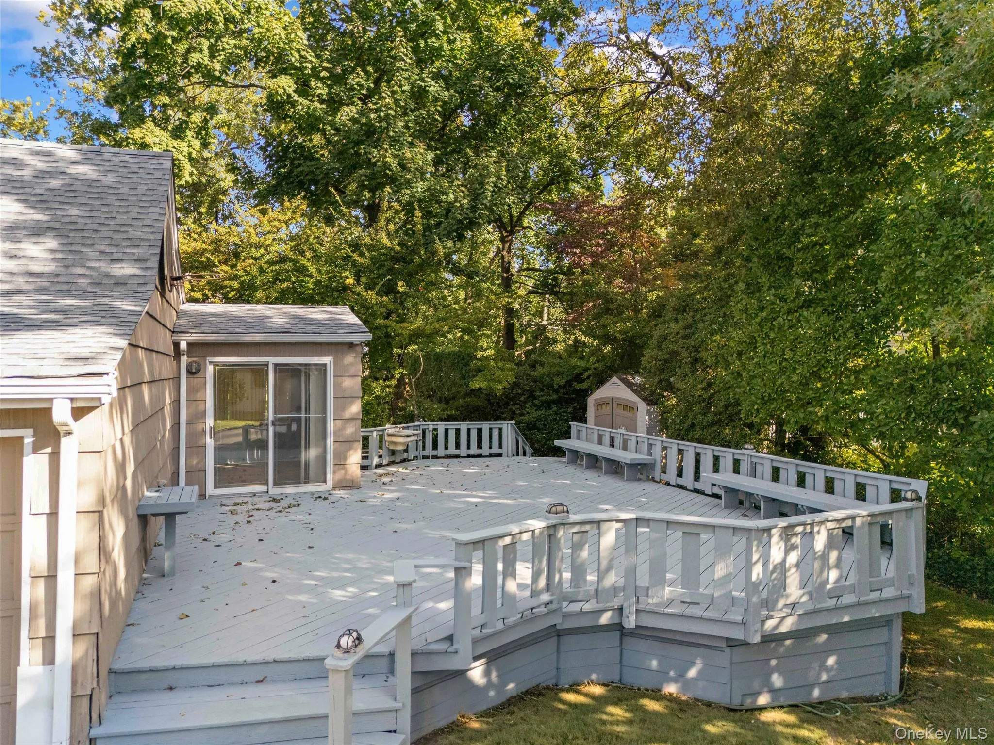 Deck with view of wooded area and a shed Deck with view of wooded area and a shed