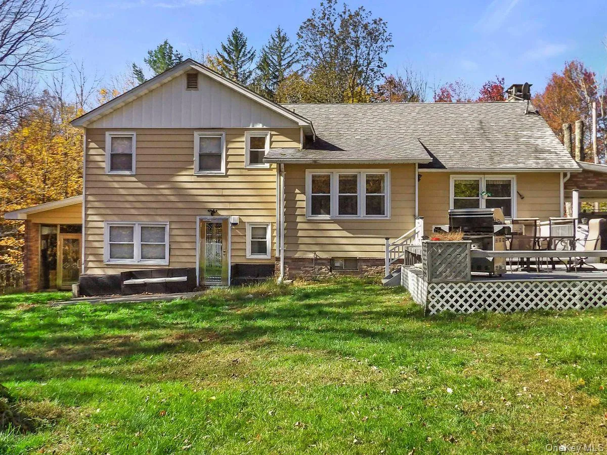 Rear view of house featuring a yard, a shingled roof, and a wooden deck Rear view of house featuring a yard, a shingled roof, and a wooden deck