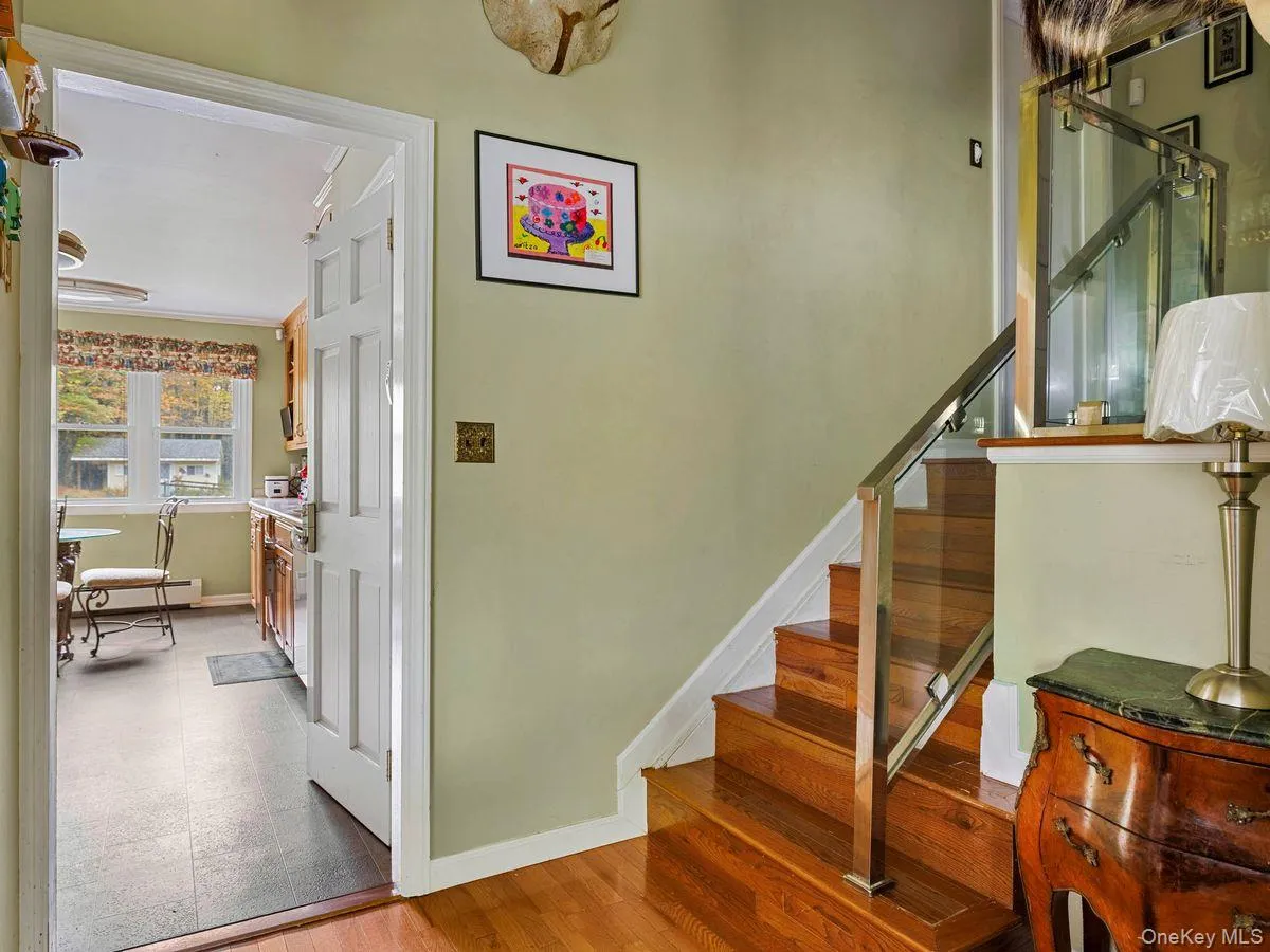 Stairs featuring wood finished floors and a baseboard heating unit Stairs featuring wood finished floors and a baseboard heating unit