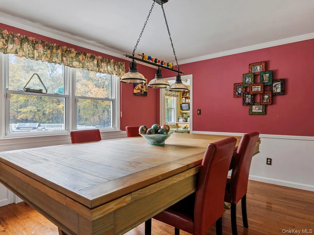 Dining space featuring dark wood-type flooring and ornamental molding Dining space featuring dark wood-type flooring and ornamental molding