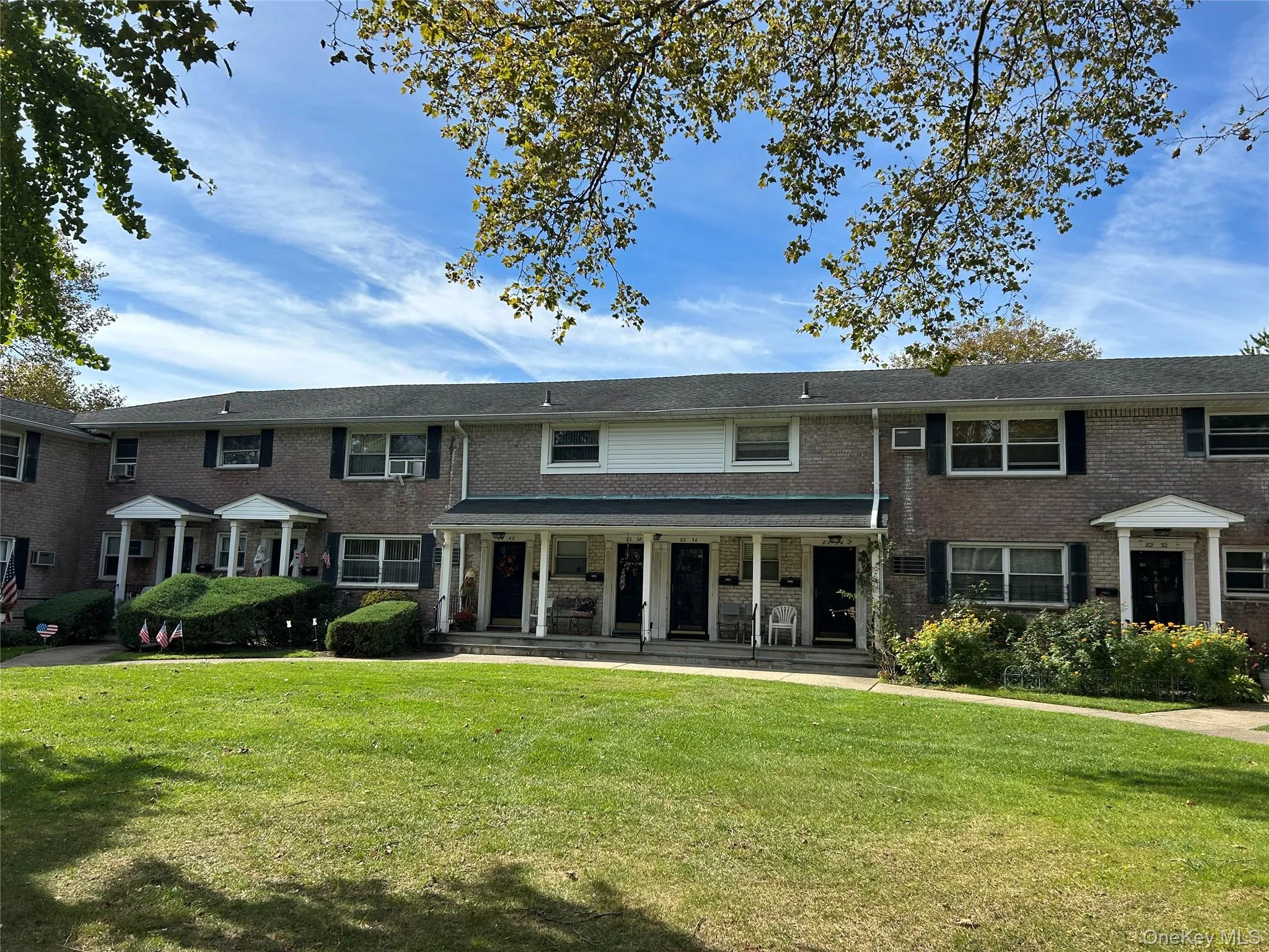 View of front of home featuring a front lawn, brick siding, and covered porch View of front of home featuring a front lawn, brick siding, and covered porch