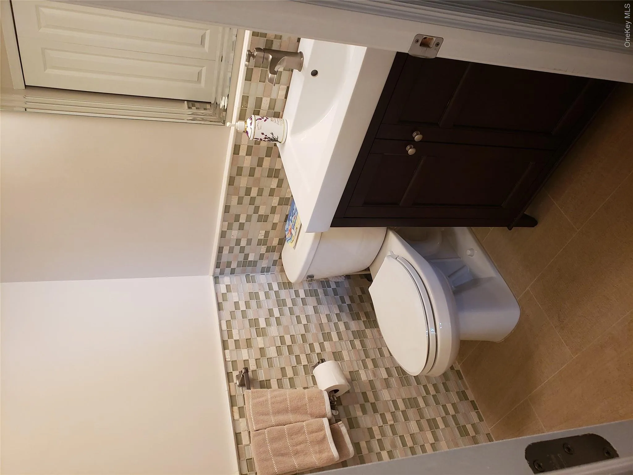Half bath with tile walls, a wainscoted wall, vanity, and tile patterned floors Half bath with tile walls, a wainscoted wall, vanity, and tile patterned floors