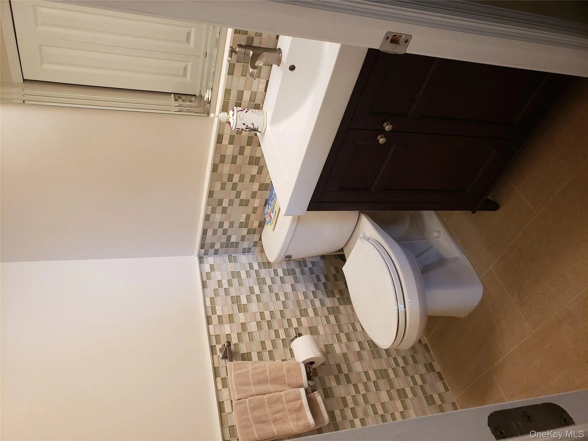 Half bath with tile walls, a wainscoted wall, vanity, and tile patterned floors Half bath with tile walls, a wainscoted wall, vanity, and tile patterned floors