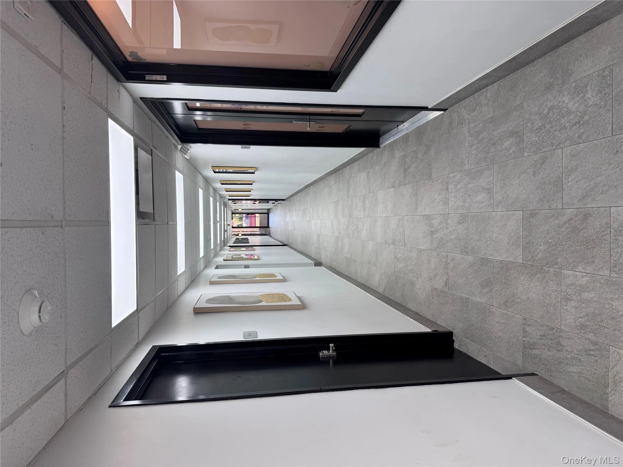 Hallway featuring baseboards and a drop ceiling Hallway featuring baseboards and a drop ceiling