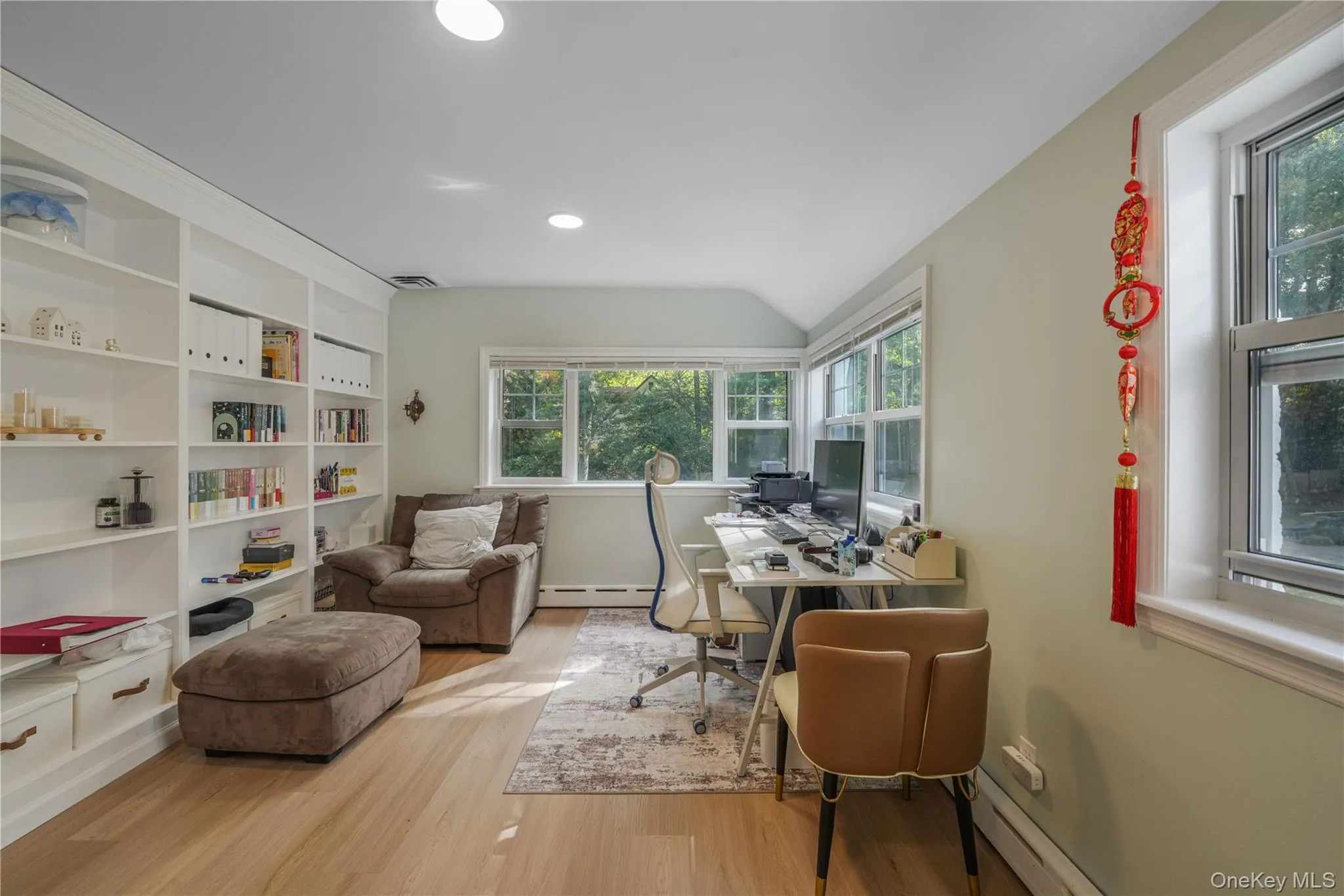 Office area with light wood-style flooring, a baseboard heating unit, lofted ceiling, recessed lighting, and built in features Office area with light wood-style flooring, a baseboard heating unit, lofted ceiling, recessed lighting, and built in features