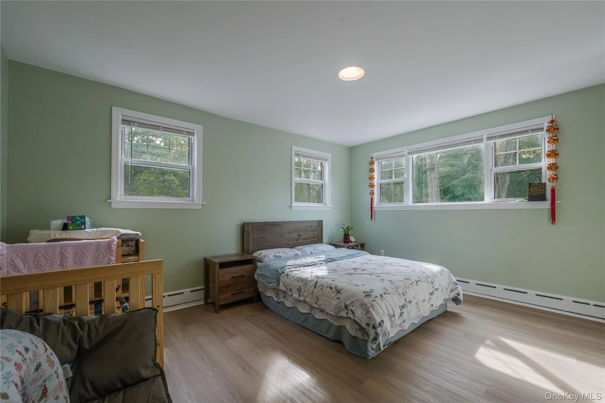 Bedroom with wood finished floors, a baseboard heating unit, and recessed lighting Bedroom with wood finished floors, a baseboard heating unit, and recessed lighting