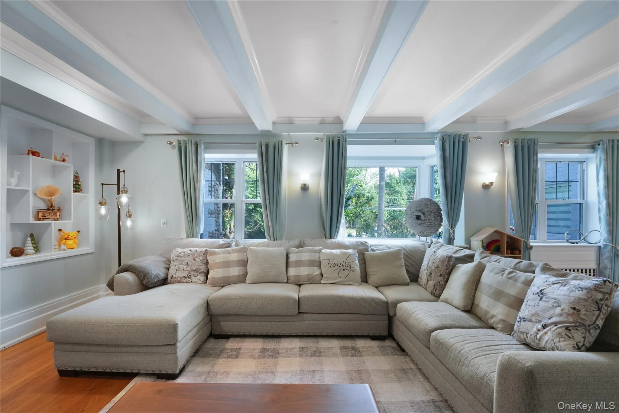 Living room with beamed ceiling, wood finished floors, built in features, and crown molding Living room with beamed ceiling, wood finished floors, built in features, and crown molding