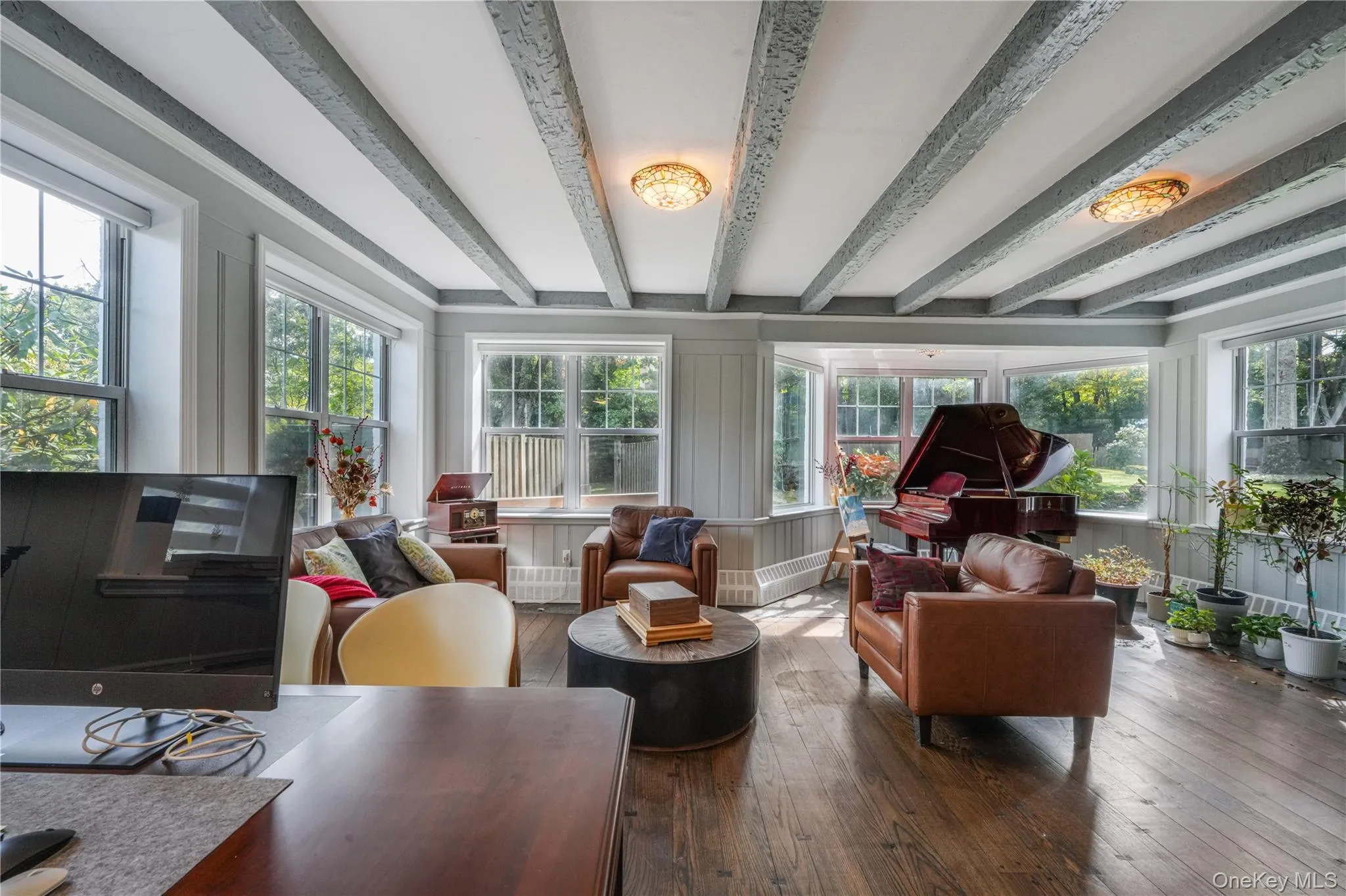 Sunroom / solarium with beam ceiling and hardwood / wood-style flooring Sunroom / solarium with beam ceiling and hardwood / wood-style flooring