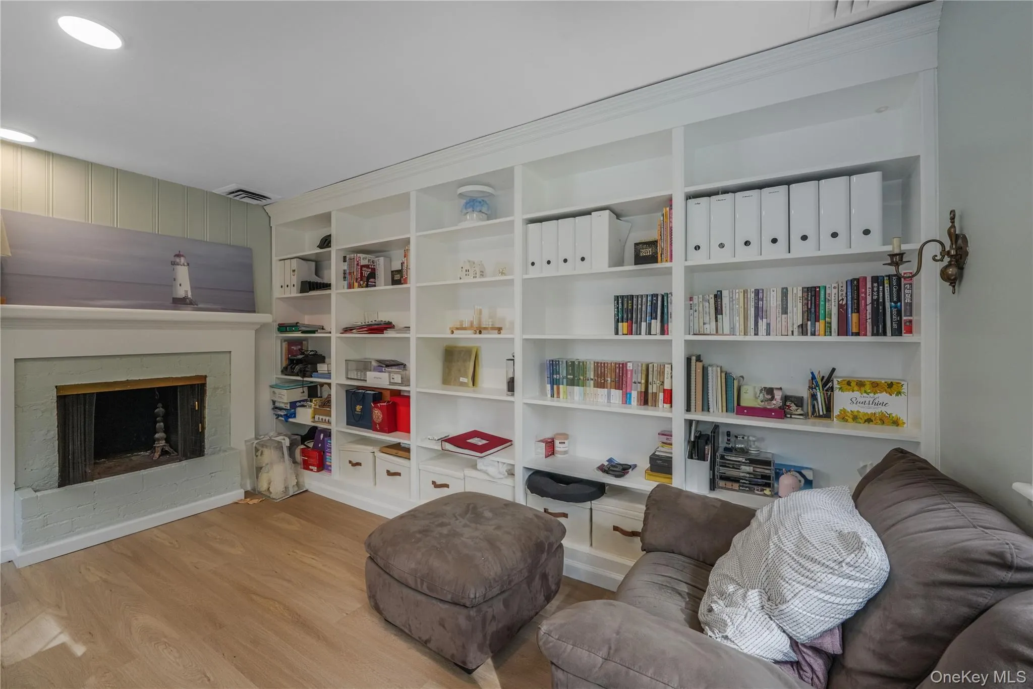 Living area with light wood-type flooring, a fireplace, and recessed lighting Living area with light wood-type flooring, a fireplace, and recessed lighting