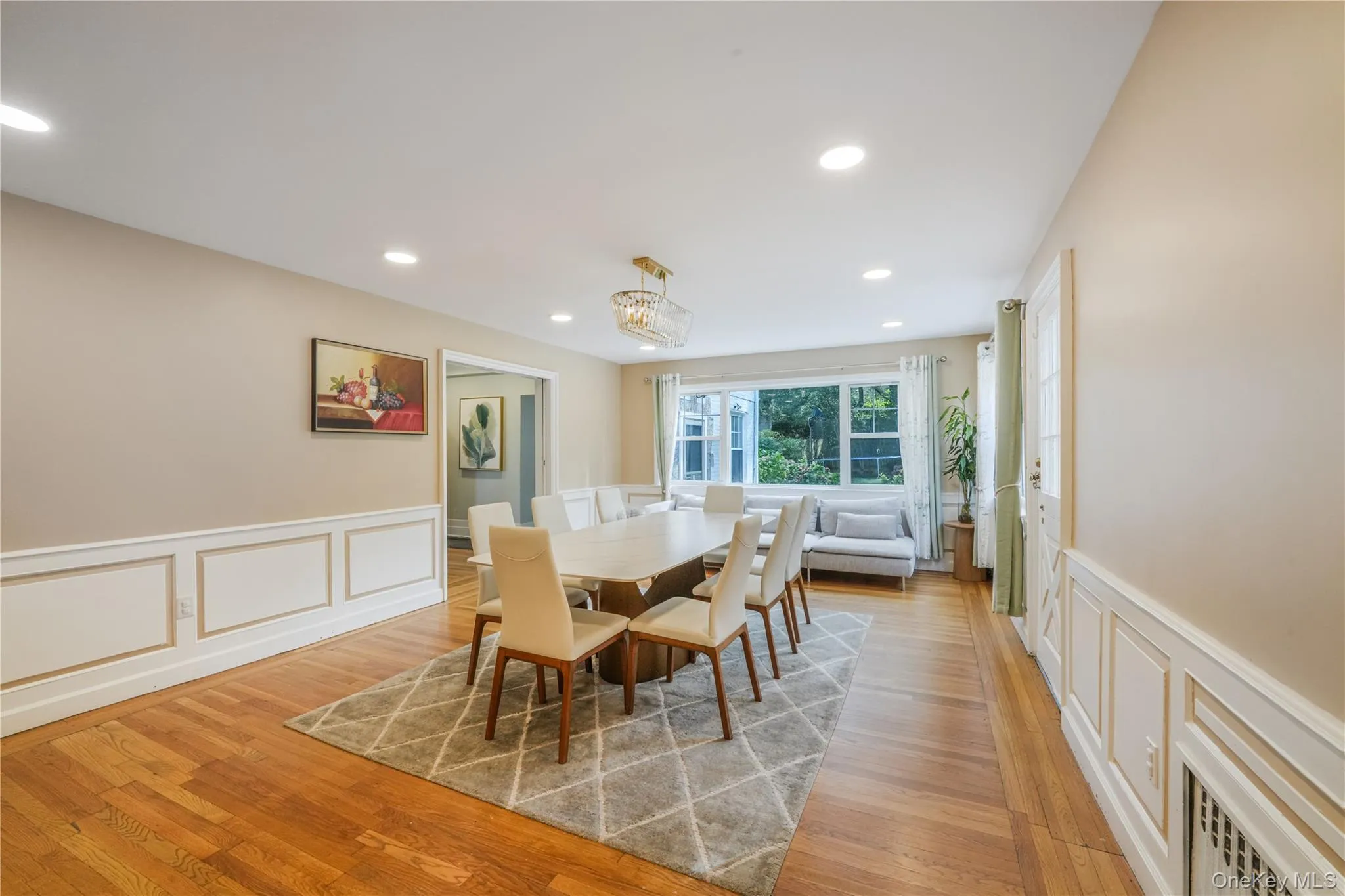 Dining area featuring a decorative wall, a wainscoted wall, recessed lighting, light wood-style flooring, and a chandelier Dining area featuring a decorative wall, a wainscoted wall, recessed lighting, light wood-style flooring, and a chandelier