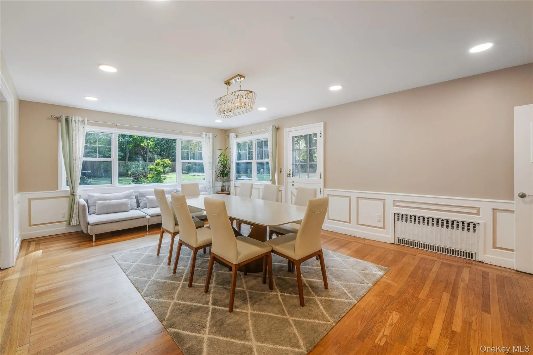 Dining area with a decorative wall, a wainscoted wall, radiator, light wood-type flooring, and recessed lighting Dining area with a decorative wall, a wainscoted wall, radiator, light wood-type flooring, and recessed lighting
