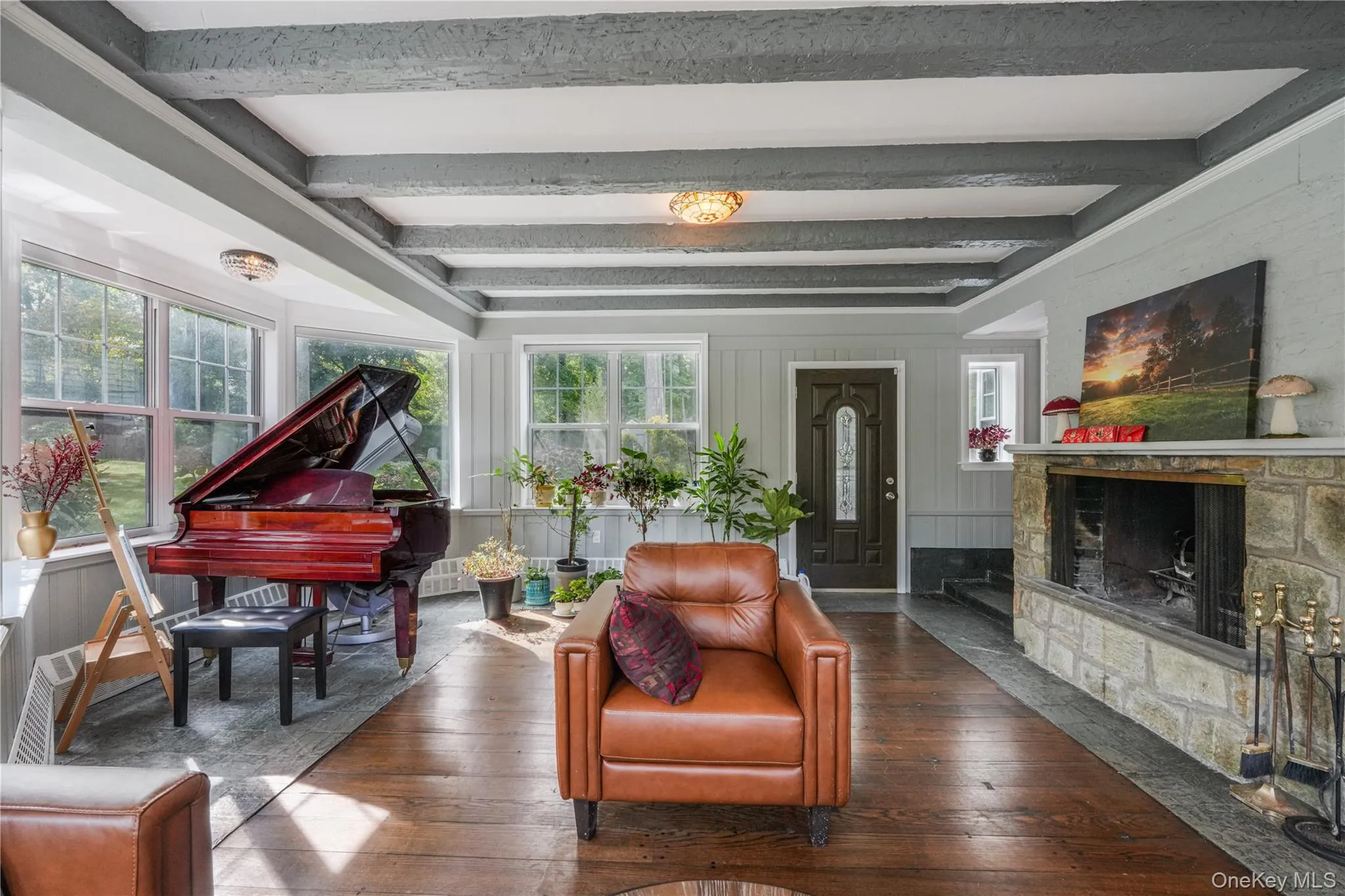 Living area with hardwood / wood-style flooring, beamed ceiling, and a fireplace Living area with hardwood / wood-style flooring, beamed ceiling, and a fireplace