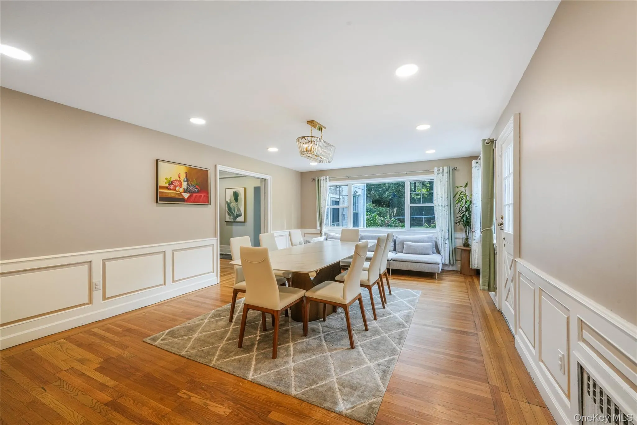 Dining space featuring a decorative wall, wainscoting, recessed lighting, and light wood finished floors Dining space featuring a decorative wall, wainscoting, recessed lighting, and light wood finished floors