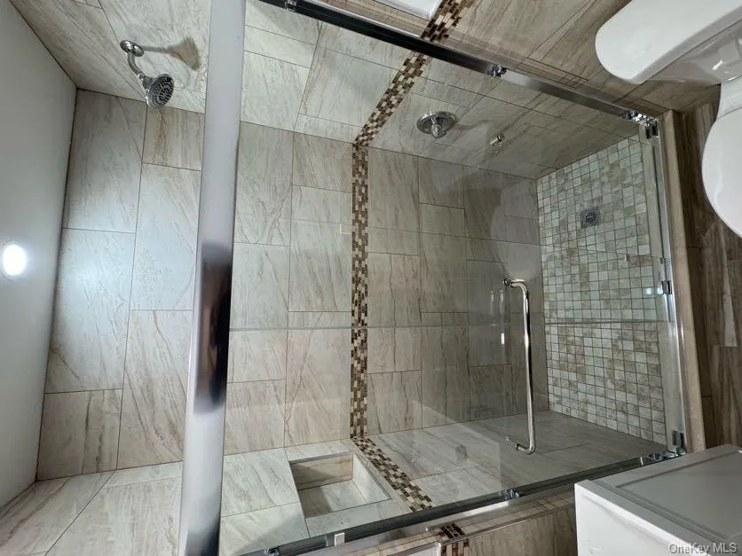 Full bath featuring a shower stall and vanity Full bath featuring a shower stall and vanity