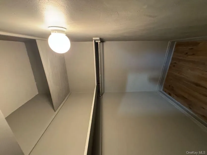 Walk in closet with dark wood-style floors Walk in closet with dark wood-style floors