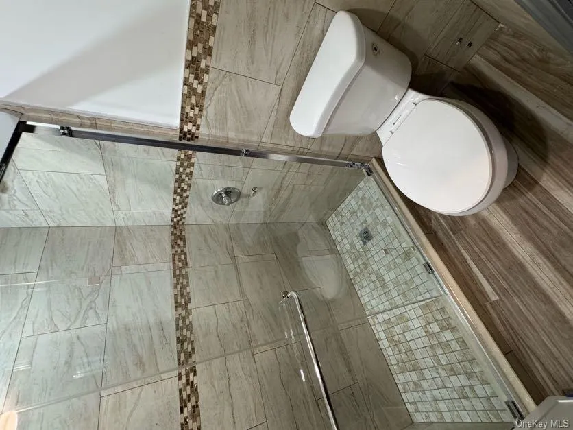 Bathroom with a shower stall and tile walls Bathroom with a shower stall and tile walls