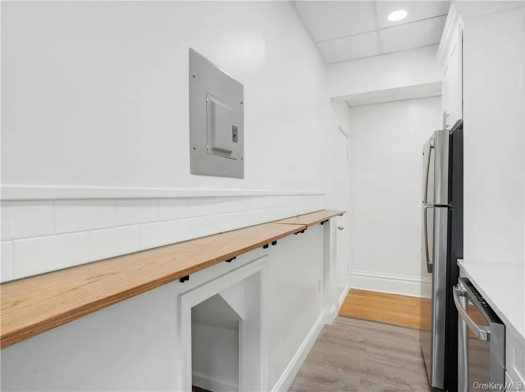 Kitchen with wooden counters, light wood-style flooring, white cabinetry, electric panel, and recessed lighting Kitchen with wooden counters, light wood-style flooring, white cabinetry, electric panel, and recessed lighting