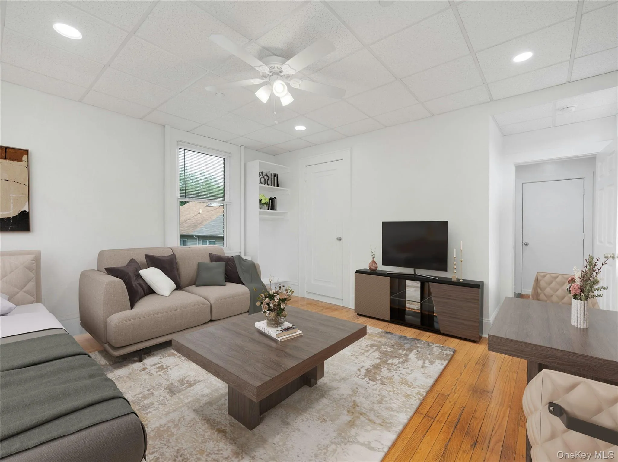 Virtually staged. Living area with a ceiling fan, hardwood / wood-style floors, recessed lighting, and a paneled ceiling Virtually staged. Living area with a ceiling fan, hardwood / wood-style floors, recessed lighting, and a paneled ceiling
