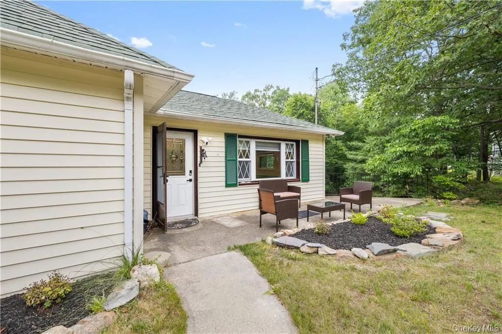 Entrance to property with a patio, a shingled roof, an outdoor living space, and a yard Entrance to property with a patio, a shingled roof, an outdoor living space, and a yard