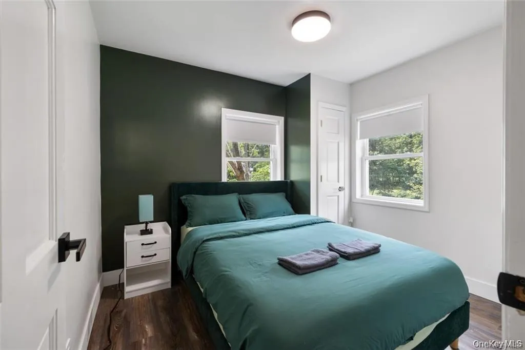 Bedroom featuring dark wood finished floors and baseboards Bedroom featuring dark wood finished floors and baseboards