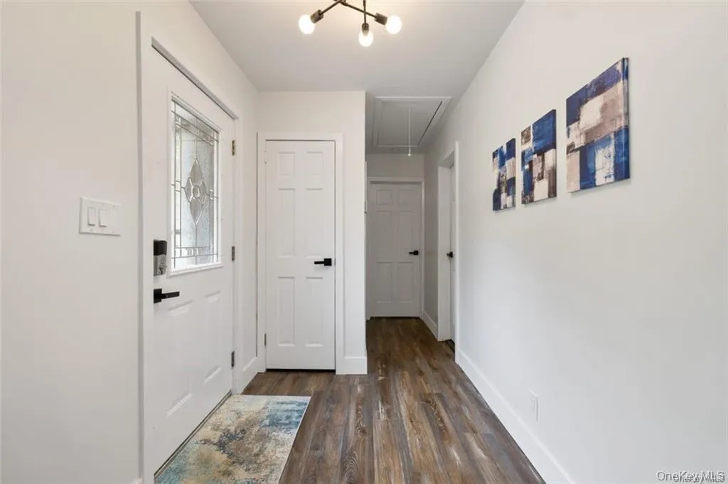 Hallway with attic access and dark wood-style floors Hallway with attic access and dark wood-style floors