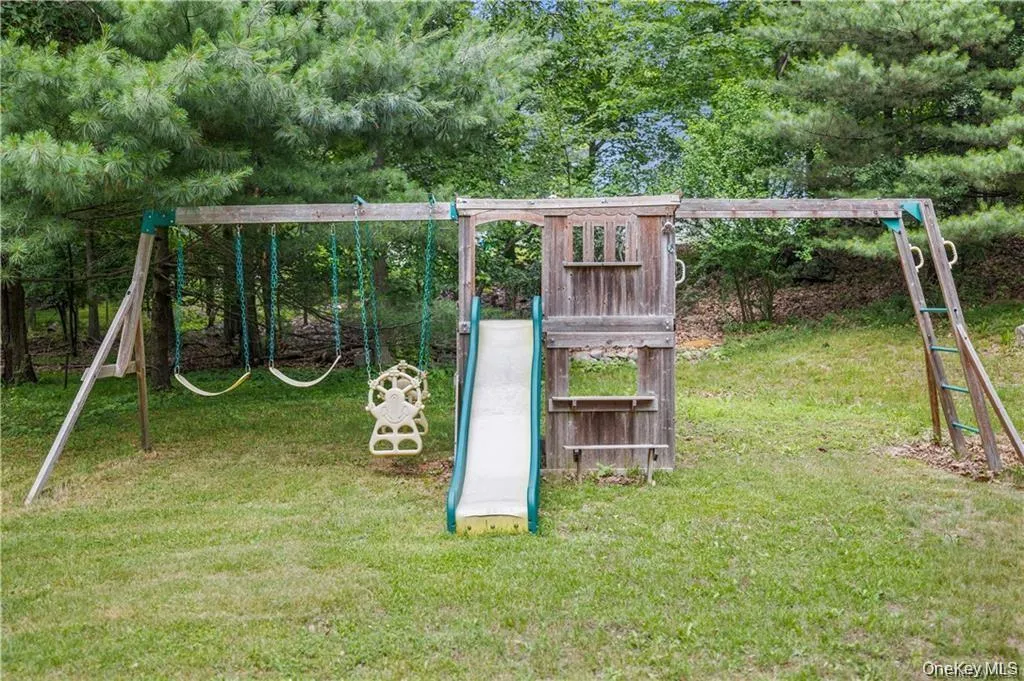 View of playground with a yard and view of wooded area View of playground with a yard and view of wooded area