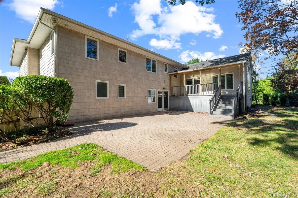 Rear view of house with a patio, a lawn, stairway, and a deck Rear view of house with a patio, a lawn, stairway, and a deck