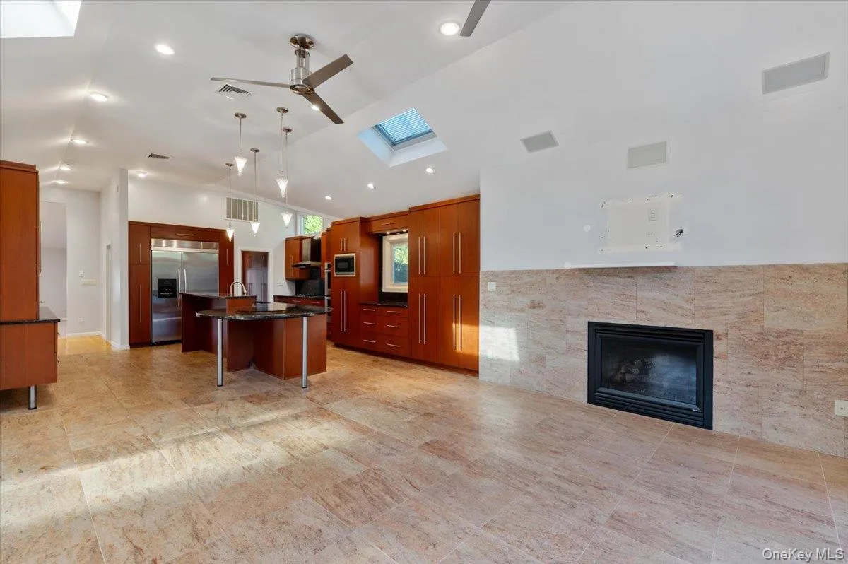 Kitchen with a kitchen breakfast bar, a skylight, an island with sink, built in appliances, and open floor plan Kitchen with a kitchen breakfast bar, a skylight, an island with sink, built in appliances, and open floor plan