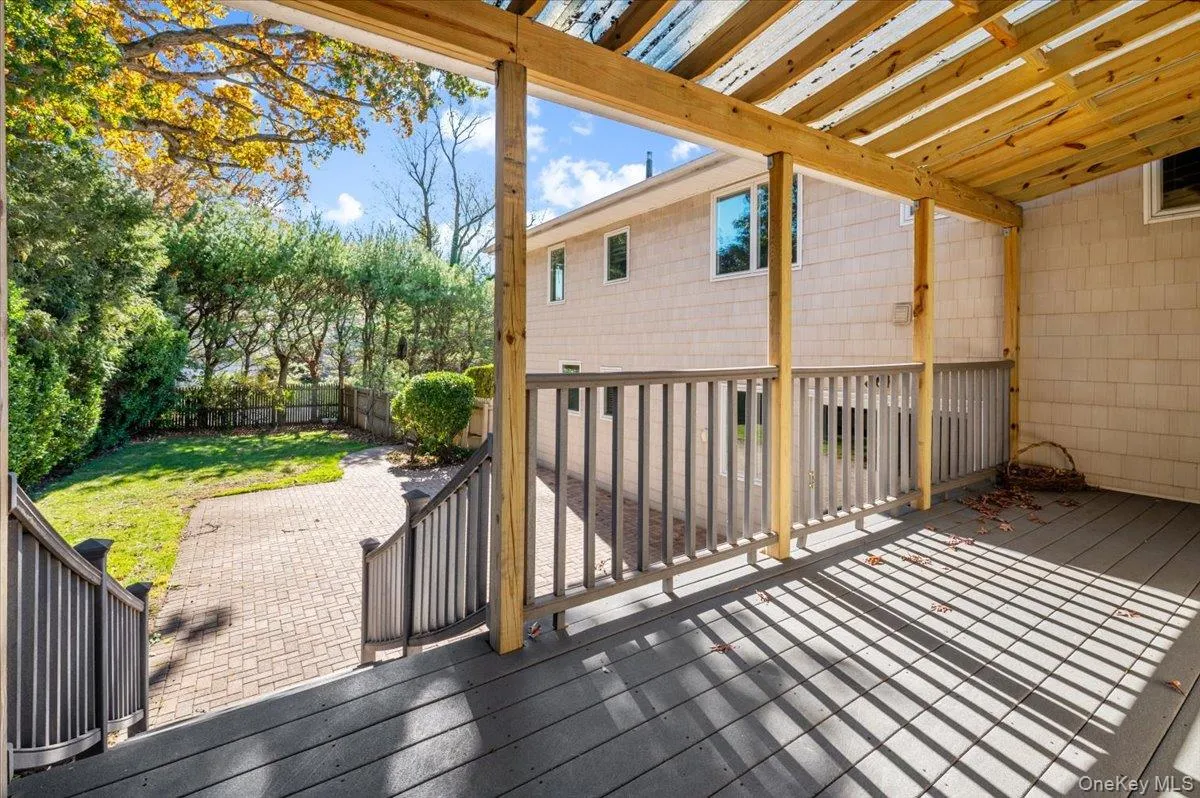 Wooden terrace with a pergola and a fenced backyard Wooden terrace with a pergola and a fenced backyard