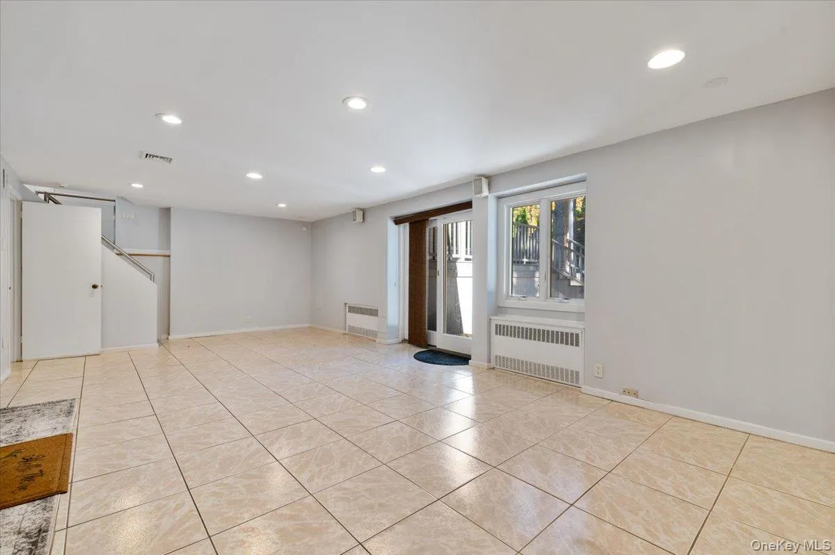 Spare room with recessed lighting, radiator, and light tile patterned flooring Spare room with recessed lighting, radiator, and light tile patterned flooring