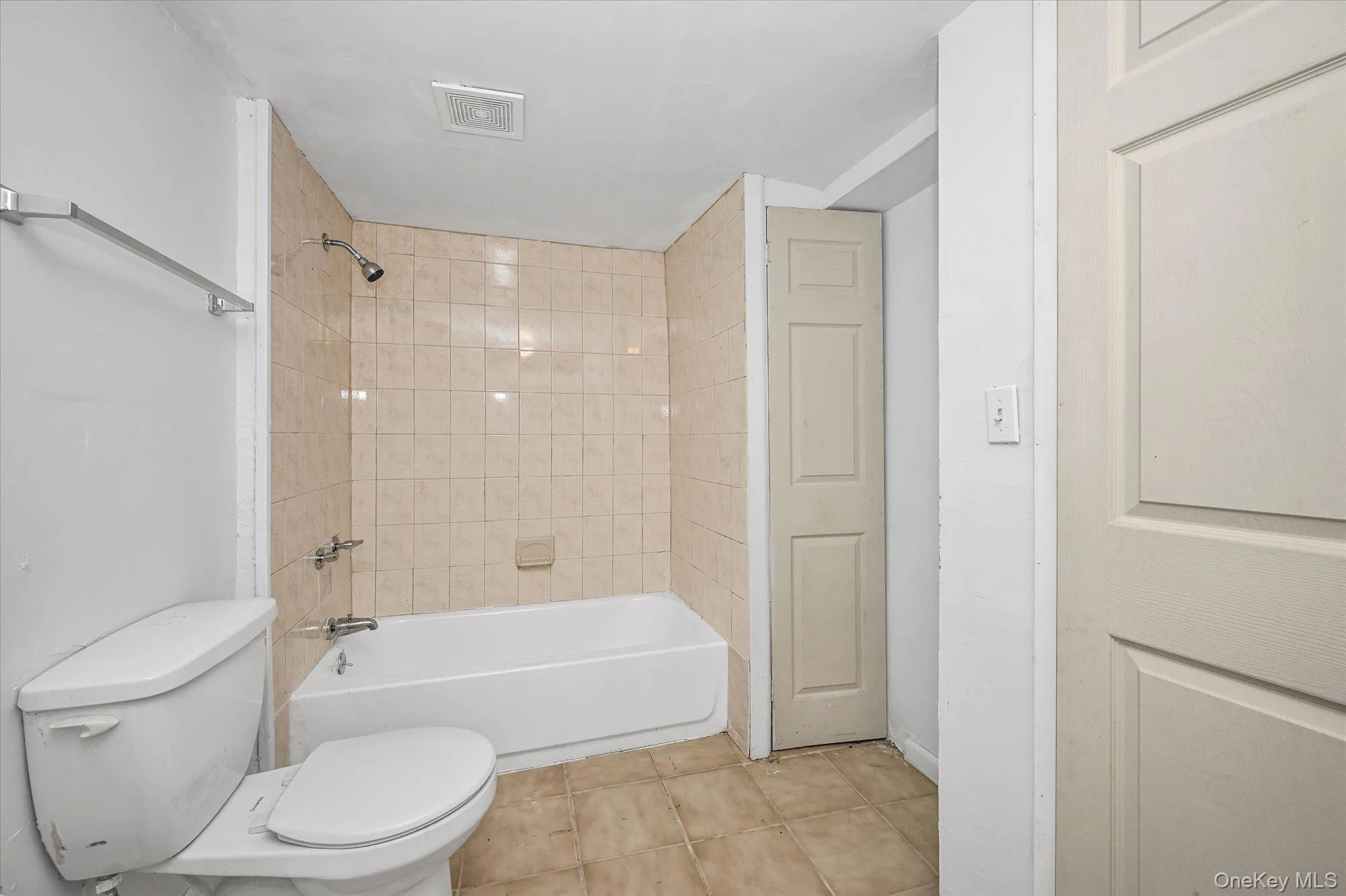 Bathroom with tile patterned floors and shower / bath combination Bathroom with tile patterned floors and shower / bath combination