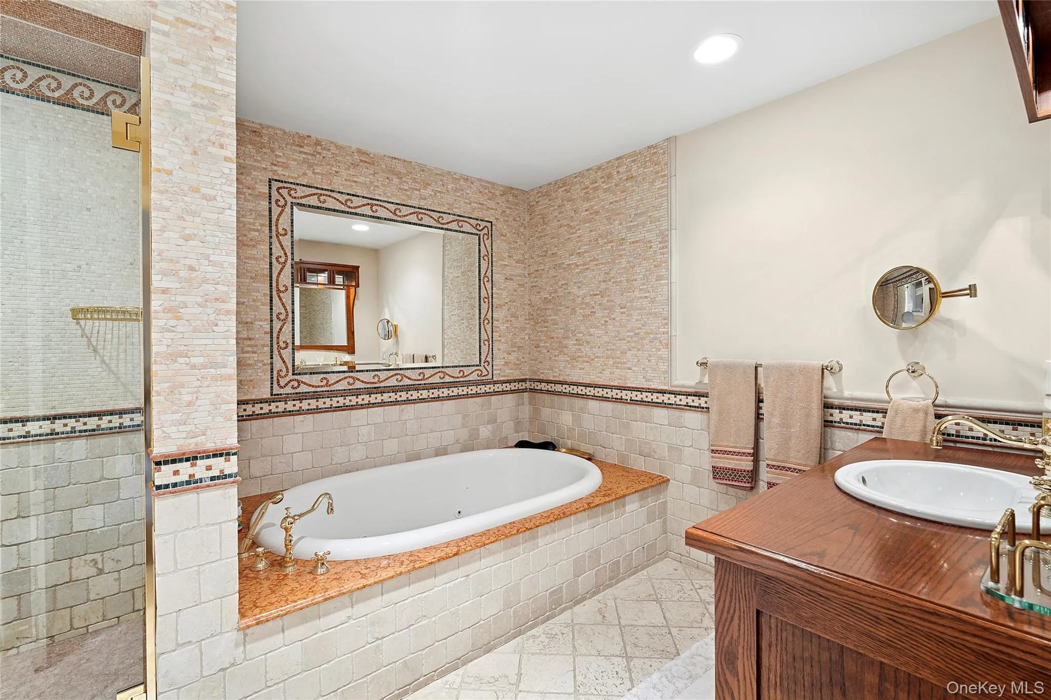 Full bathroom with tile walls, vanity, a tub with jets, recessed lighting, and wainscoting