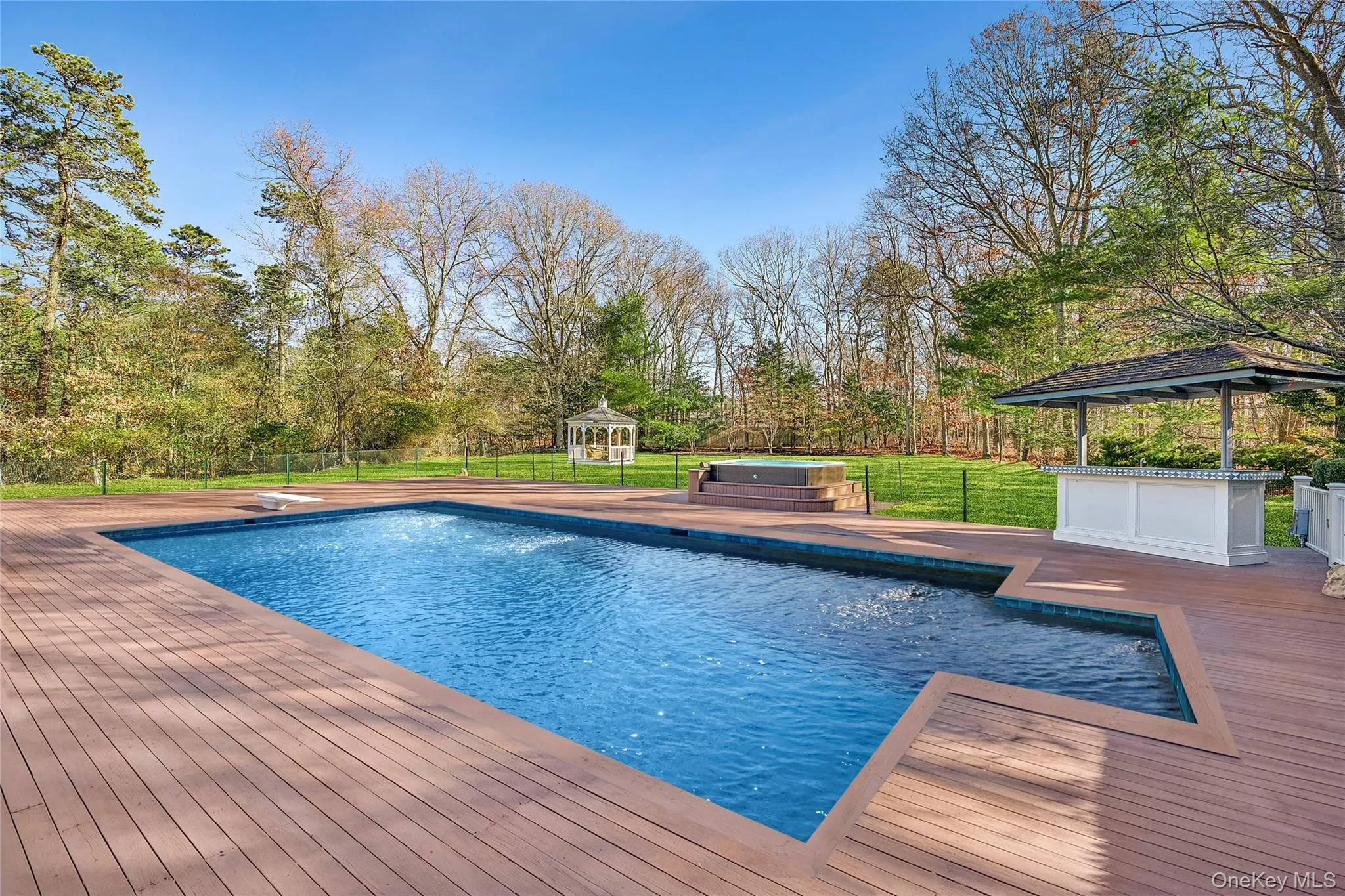 Swimming pool with a gazebo, a hot tub, and a wooden deck
