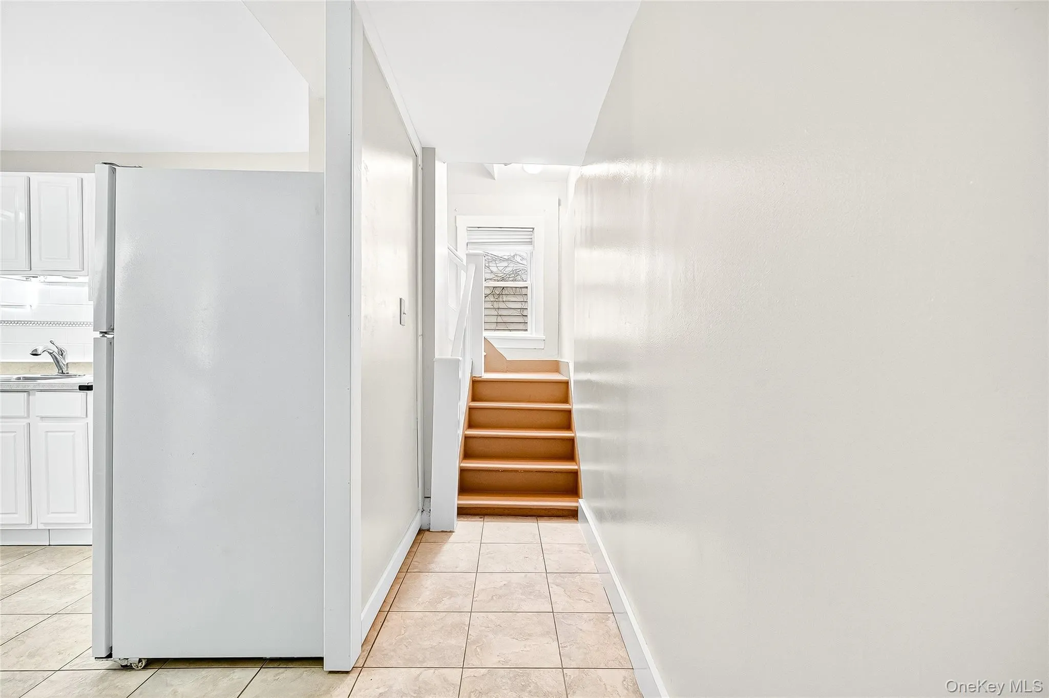 Hall with light tile patterned flooring and stairs Hall with light tile patterned flooring and stairs