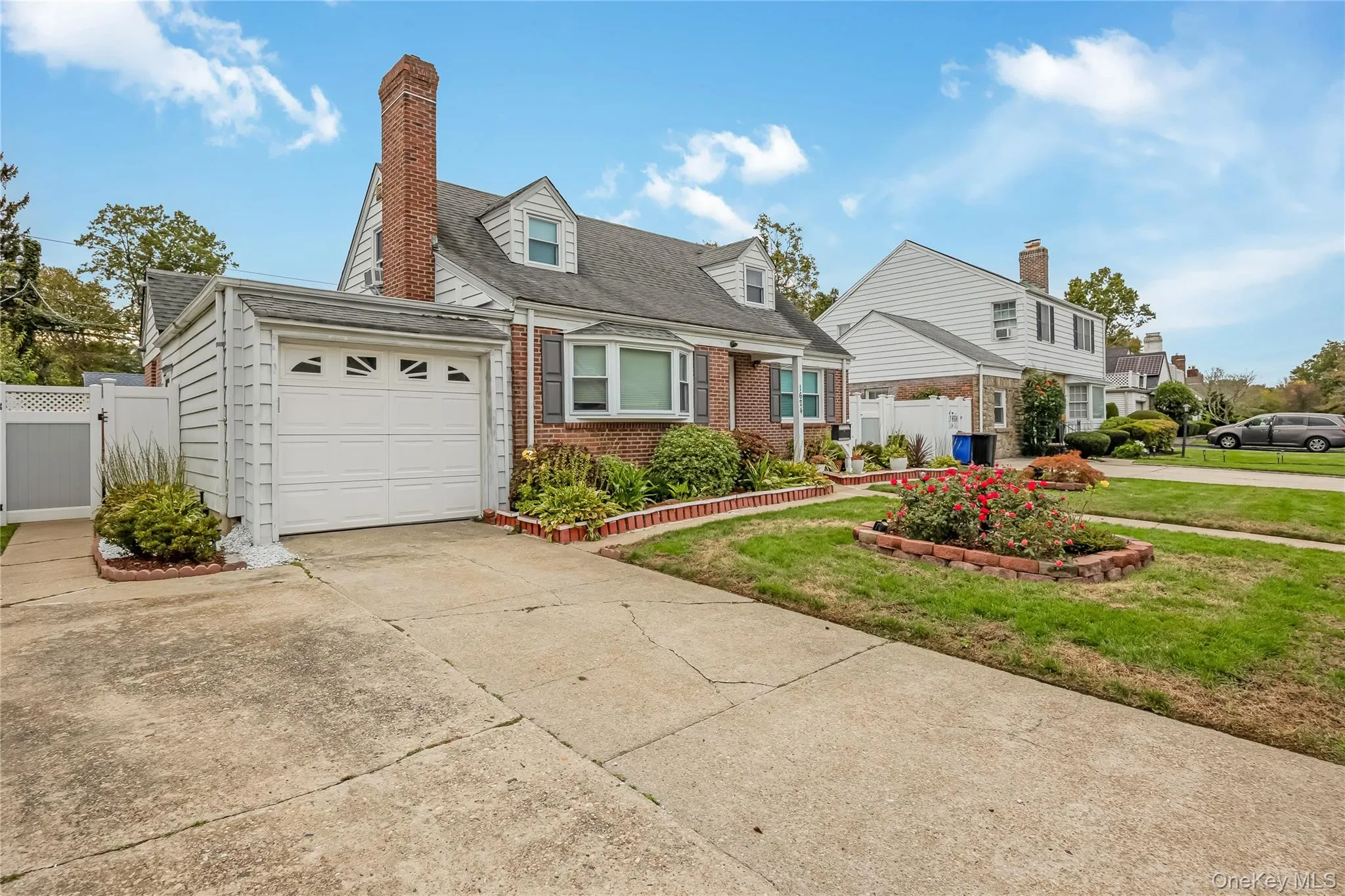 Cape cod home with brick siding, concrete driveway, a chimney, an attached garage, and a shingled roof Cape cod home with brick siding, concrete driveway, a chimney, an attached garage, and a shingled roof