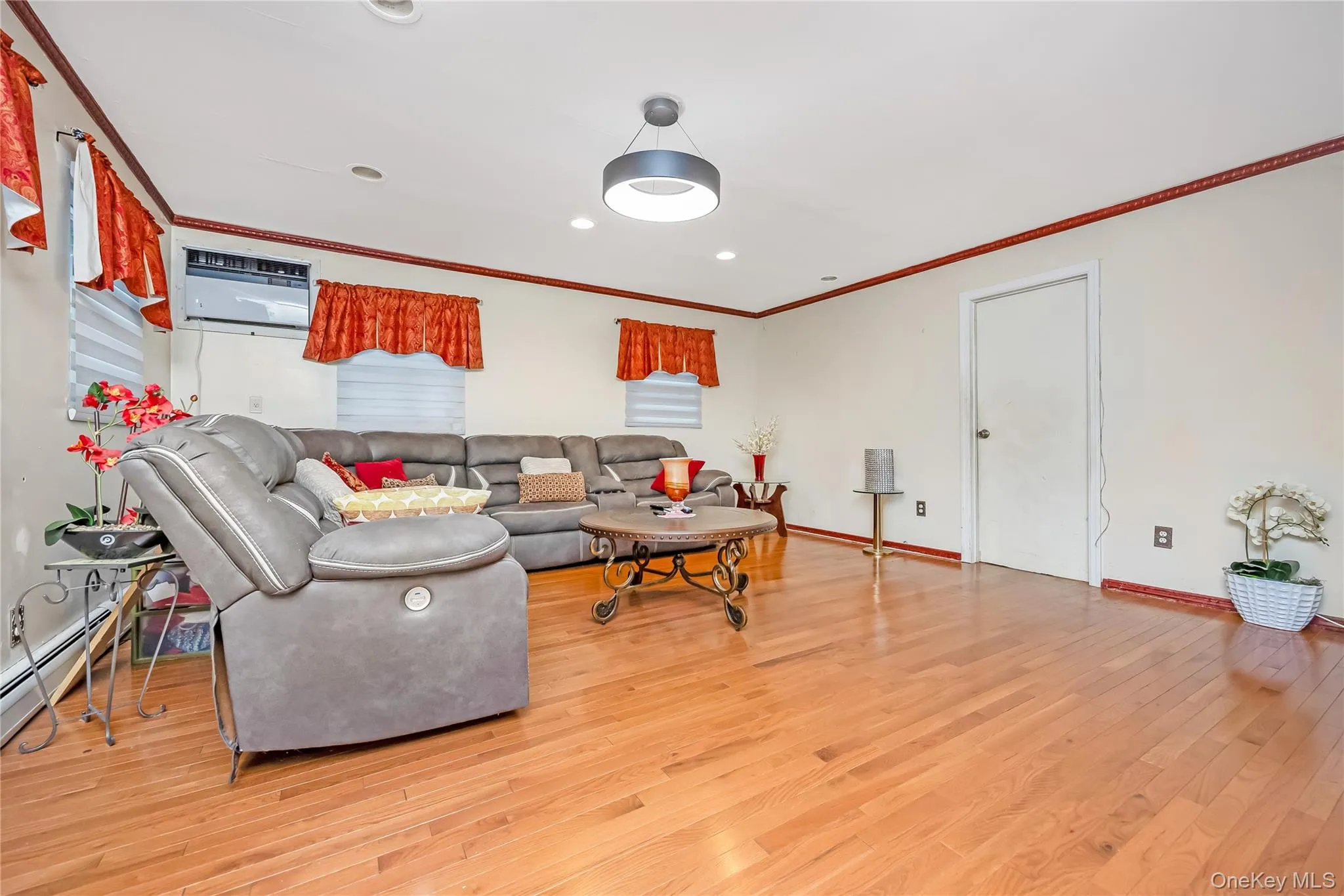 Living area with ornamental molding, light wood finished floors, and recessed lighting Living area with ornamental molding, light wood finished floors, and recessed lighting