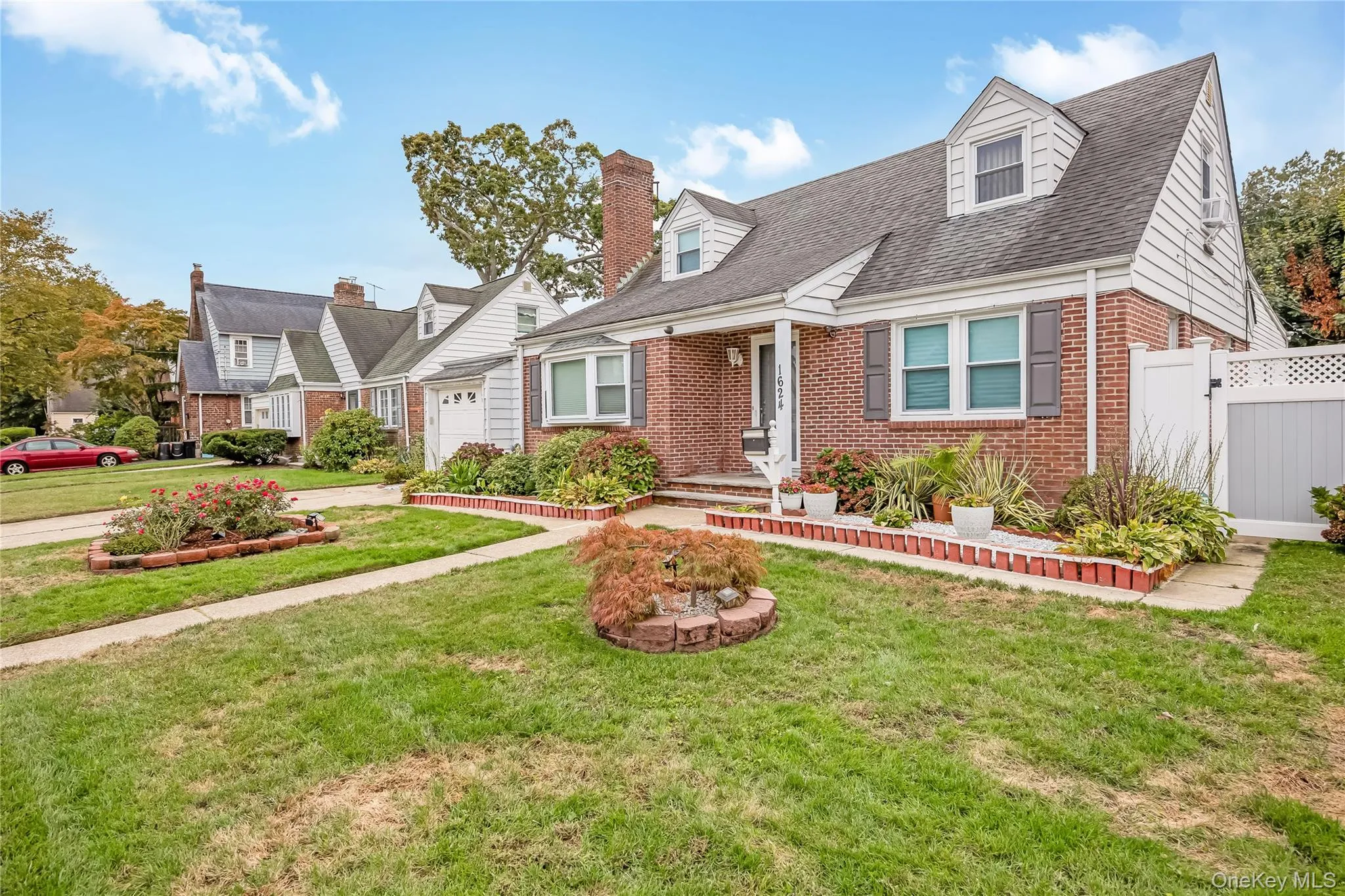 Cape cod-style house featuring brick siding, roof with shingles, and a garage Cape cod-style house featuring brick siding, roof with shingles, and a garage