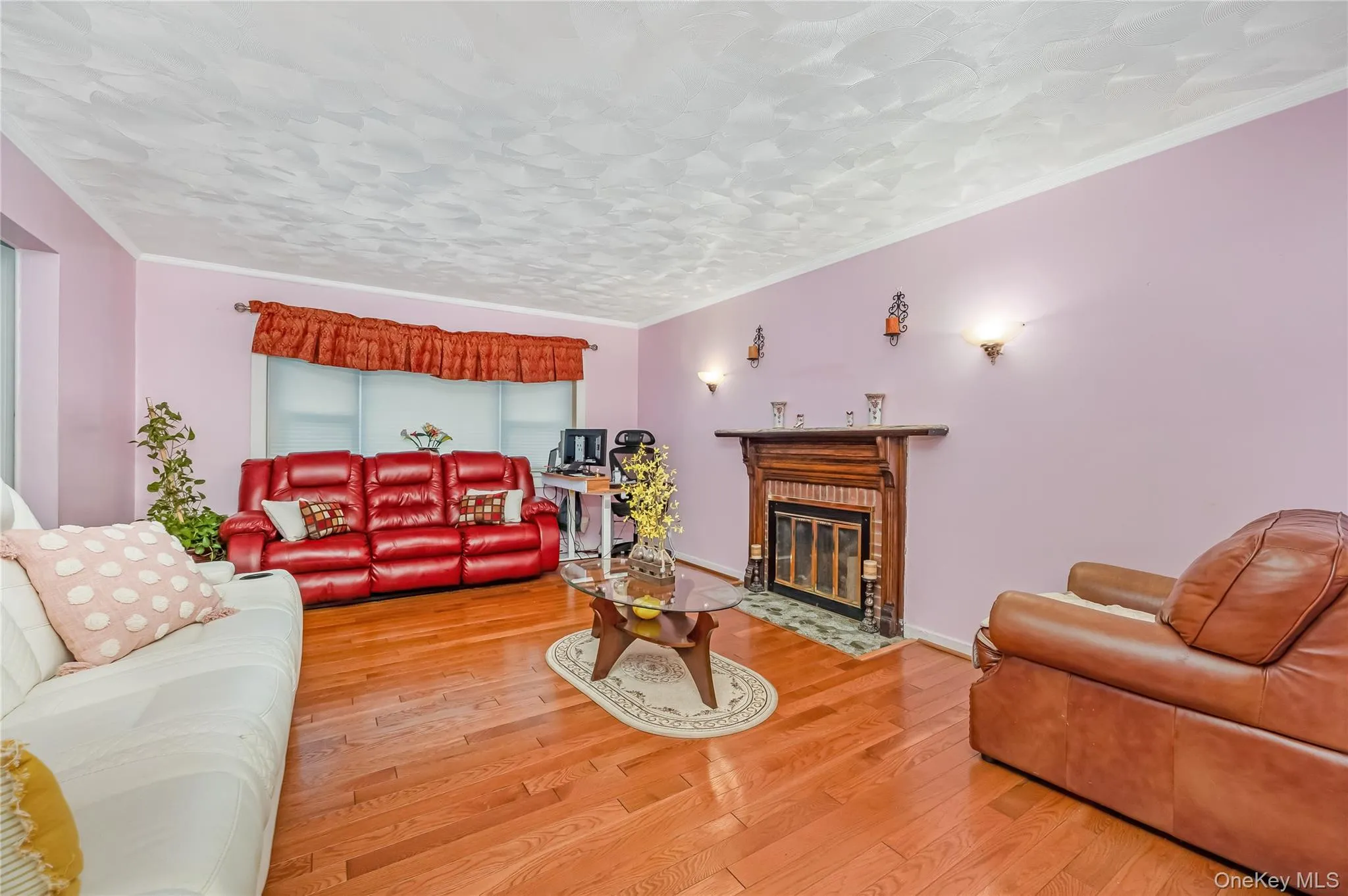 Living room featuring crown molding, wood finished floors, and a fireplace with flush hearth Living room featuring crown molding, wood finished floors, and a fireplace with flush hearth