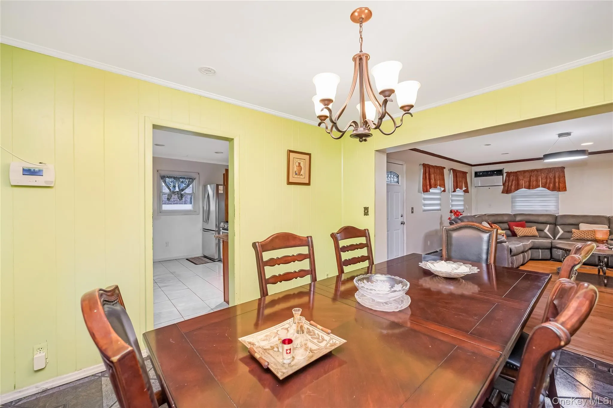 Tiled dining area with crown molding and a chandelier Tiled dining area with crown molding and a chandelier