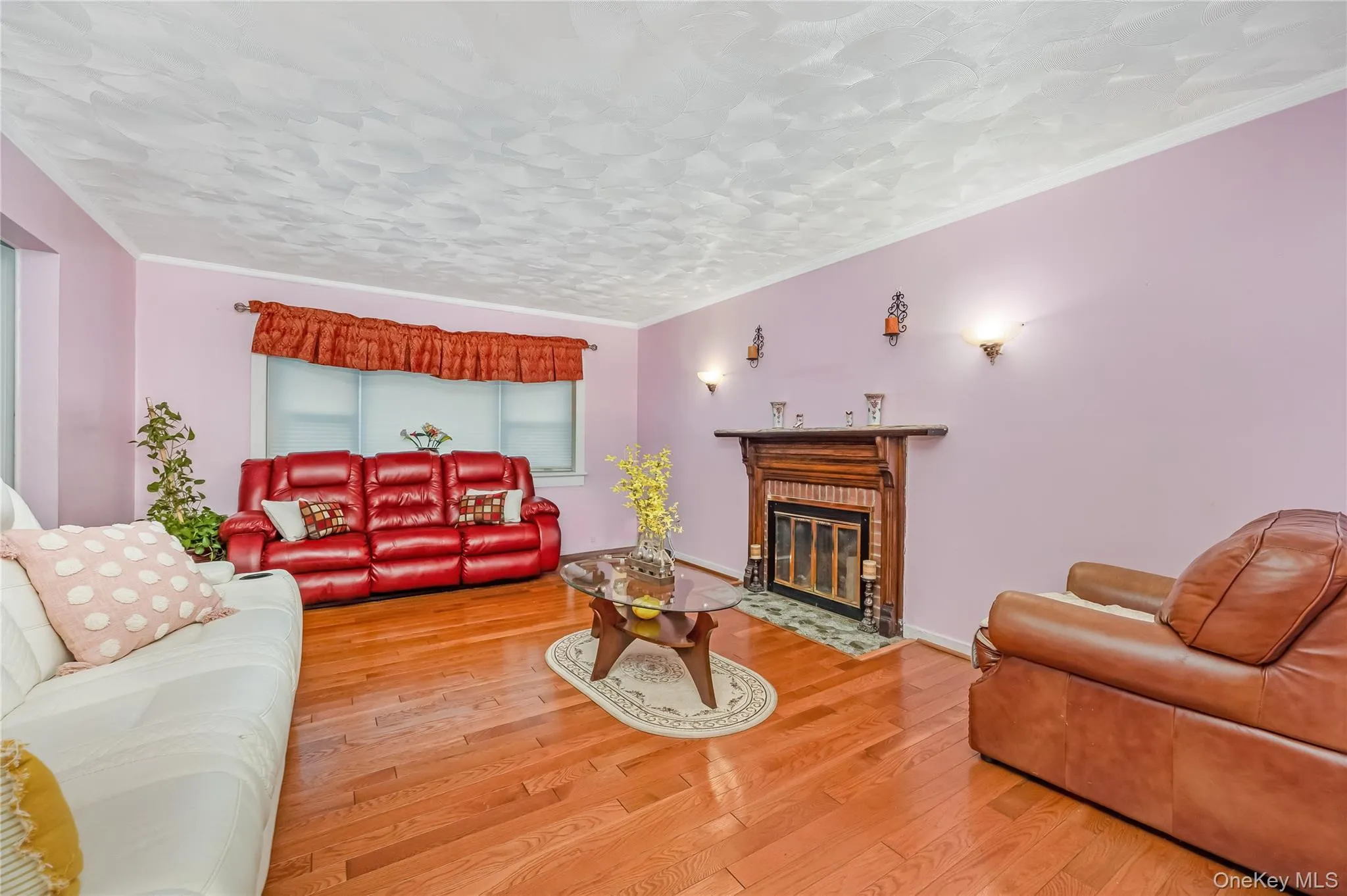 Living room with crown molding, wood finished floors, and a fireplace with flush hearth Living room with crown molding, wood finished floors, and a fireplace with flush hearth