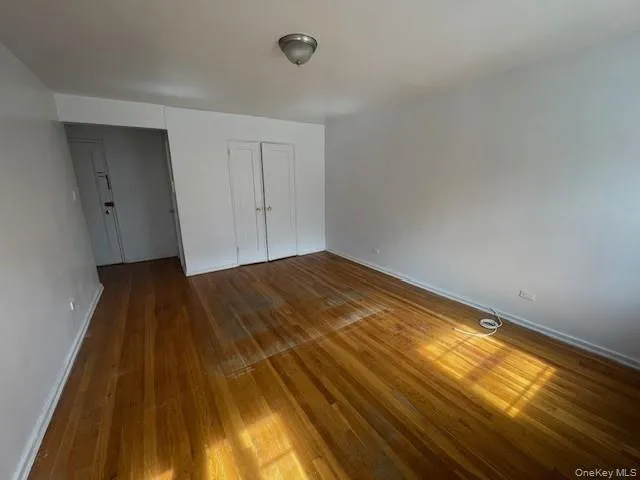 Unfurnished bedroom with hardwood / wood-style floors and a closet Unfurnished bedroom with hardwood / wood-style floors and a closet