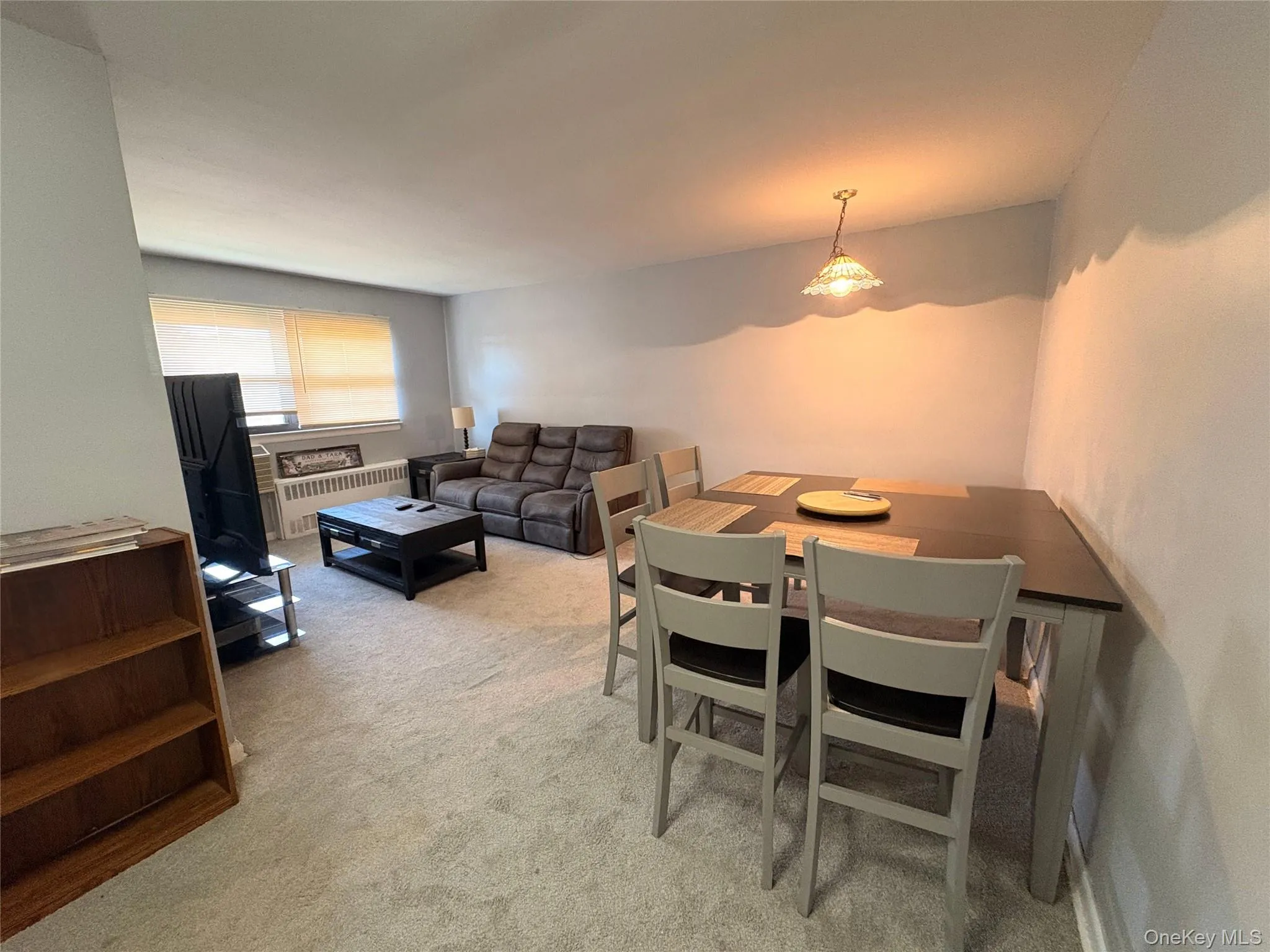 Dining room featuring light colored carpet and radiator Dining room featuring light colored carpet and radiator
