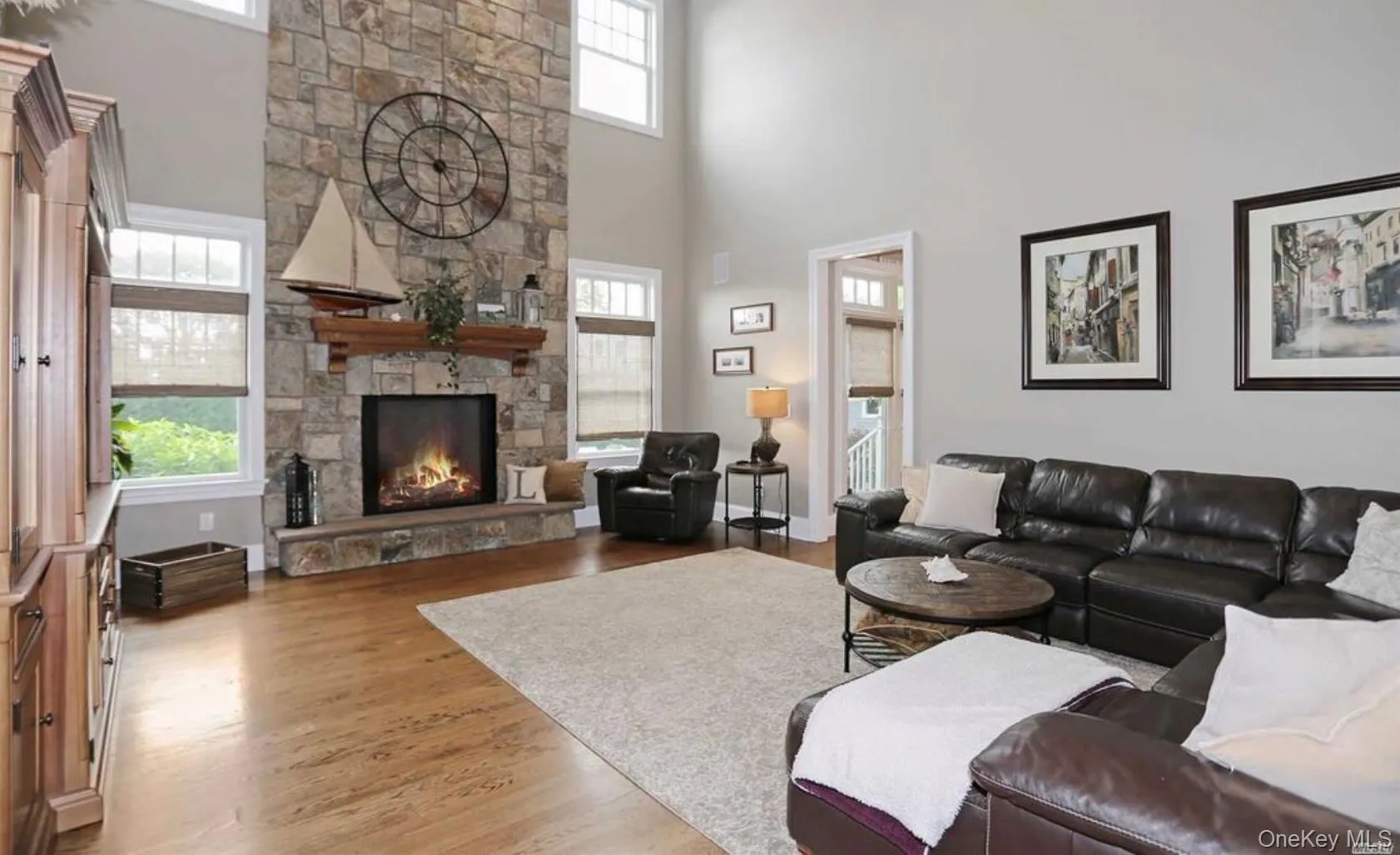 Living area featuring wood finished floors, a fireplace, and a towering ceiling Living area featuring wood finished floors, a fireplace, and a towering ceiling